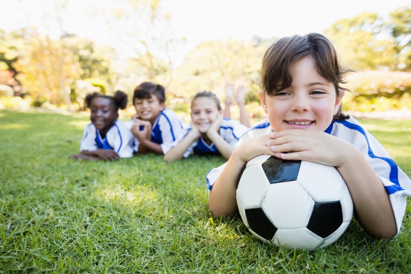 close-up-view-of-girl-lying-on-the-floor-with-her (Groß) Fußballschule Team Soccer Thomas Metzner